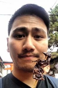 Jason is holding Fushimi Inari Sparrow on a stick in front of his face. He is not smiling.