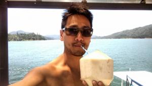 Jason is sipping from a coconut while getting some sun on a houseboat at Shasta Lake. This is a great way to travel.